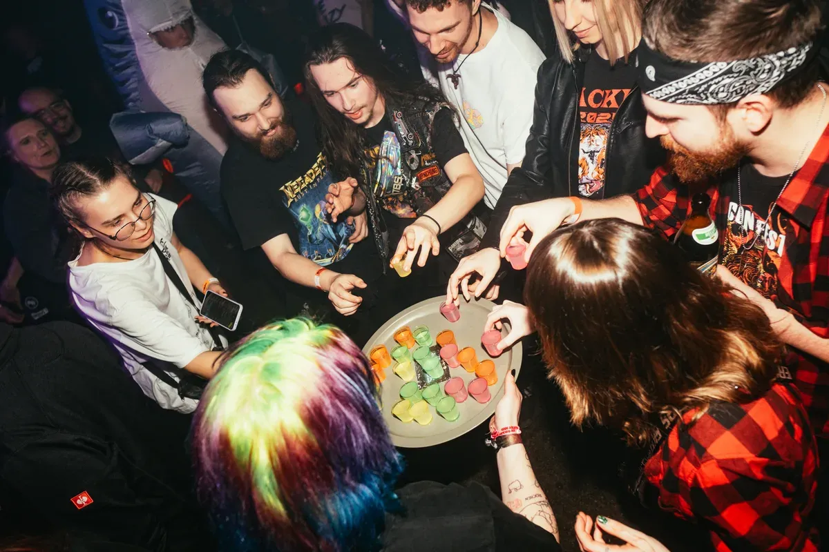 Fans greifen nach bunten Jelly-Shots auf einem Tablett