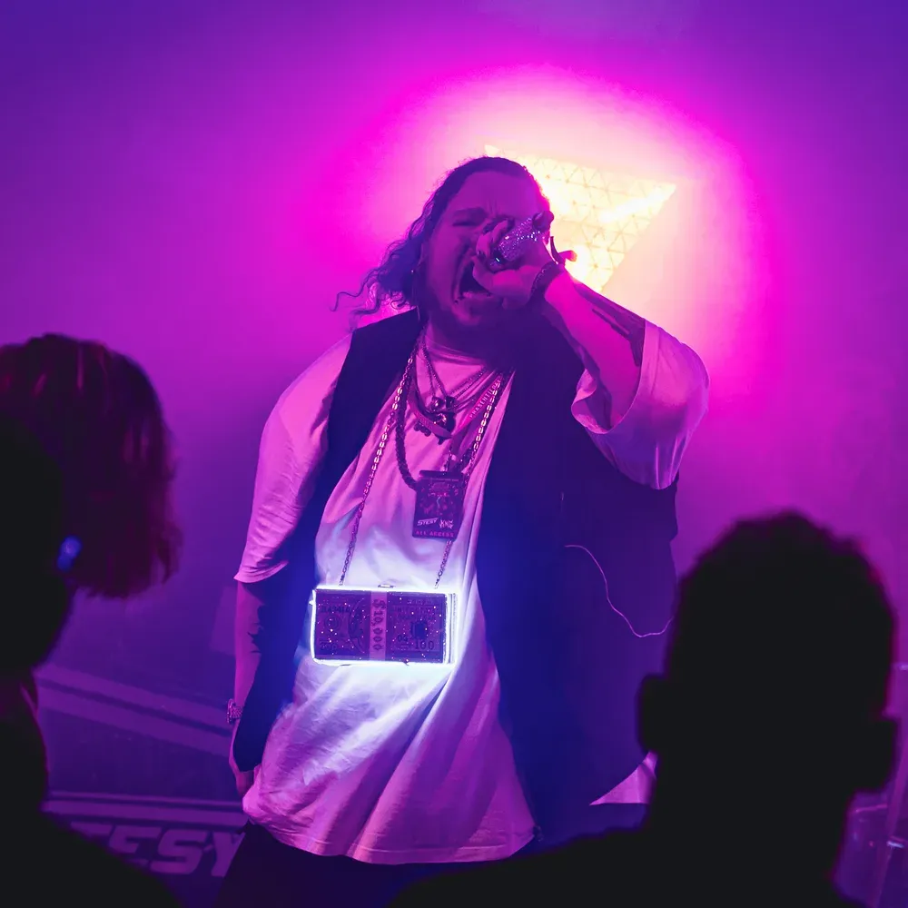 Saenger singt inmitten von pink-lila Buehnennebel